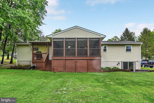 back of property with a sunroom, a yard, and stairway