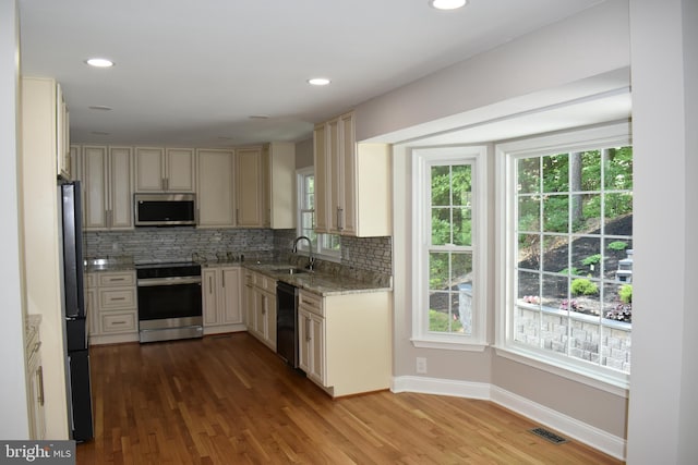 2008 Coast Guard Dr, Stafford, VA 22554 - kitchen with appliances with stainless steel finishes, light stone countertops, decorative backsplash, wood finished floors, and recessed lighting
