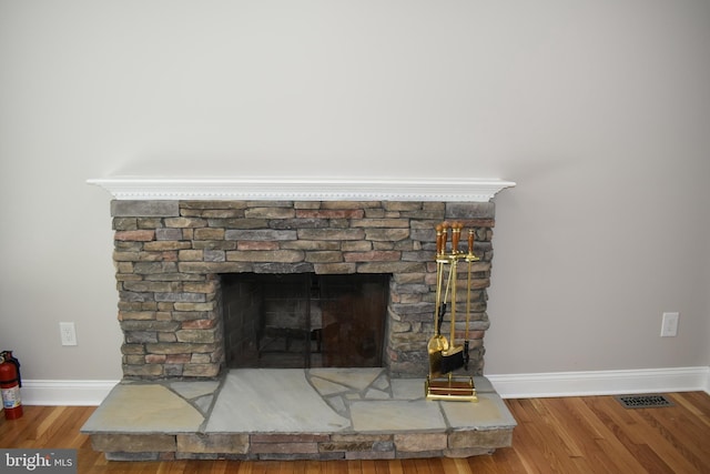 2008 Coast Guard Dr, Stafford, VA 22554 - detailed view of baseboards, a fire extinguisher, wood finished floors, and a fireplace with raised hearth