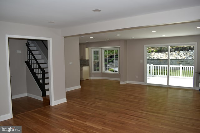 2008 Coast Guard Dr, Stafford, VA 22554 - unfurnished living room featuring wood finished floors, stairs, baseboards, and recessed lighting