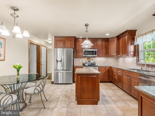 kitchen with appliances with stainless steel finishes, a sink, decorative backsplash, and light stone countertops