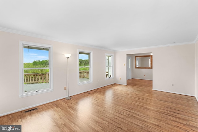 unfurnished living room with light wood-style floors, ornamental molding, and baseboards