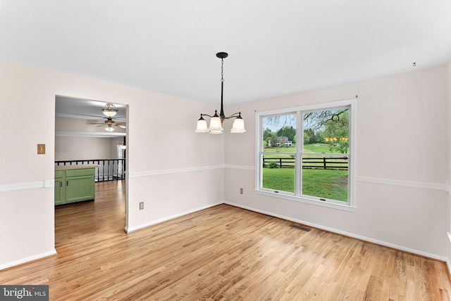 unfurnished dining area featuring light wood-style flooring, a ceiling fan, and baseboards