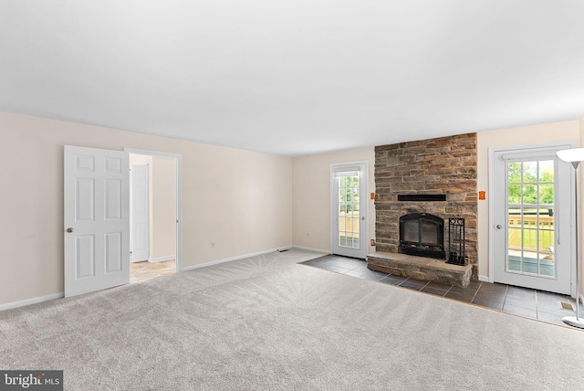 unfurnished living room featuring carpet flooring, healthy amount of natural light, baseboards, and a fireplace