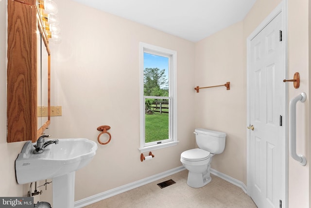 half bathroom featuring baseboards and toilet