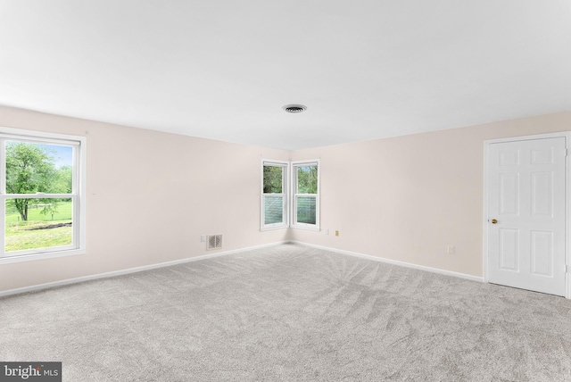 carpeted spare room featuring baseboards