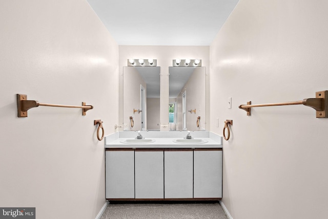 bathroom featuring double vanity and baseboards