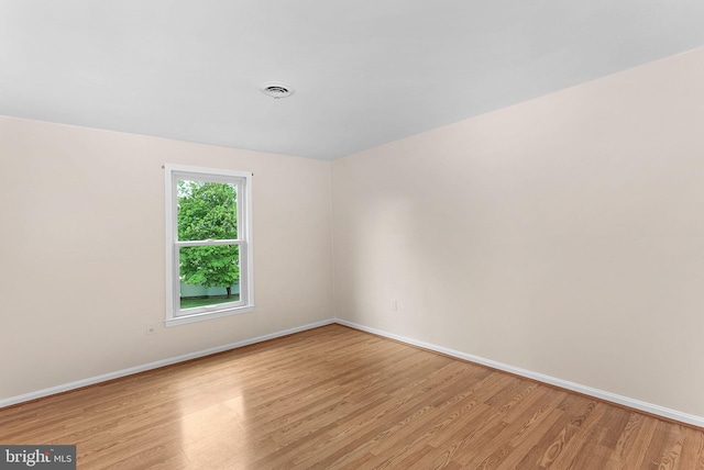 empty room with light wood-style flooring and baseboards