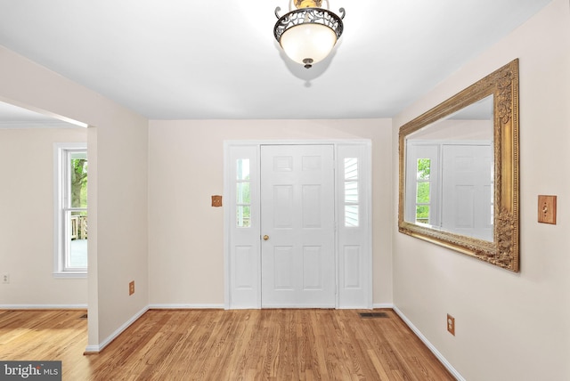 foyer entrance featuring light wood-style floors and baseboards