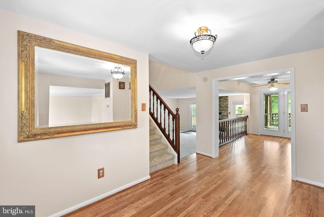 foyer featuring plenty of natural light, wood finished floors, stairs, and baseboards