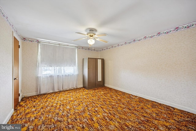 spare room featuring ceiling fan, wallpapered walls, and baseboards