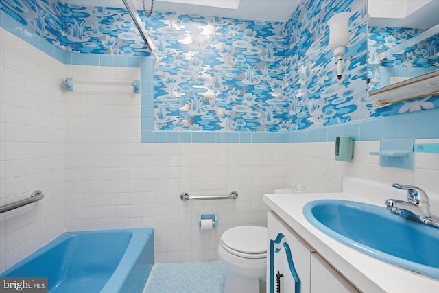 full bath with wallpapered walls, tile walls, a bathtub, toilet, and vanity