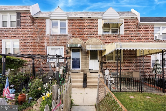 townhome / multi-family property featuring brick siding, cooling unit, and a high end roof