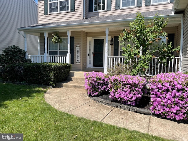 property entrance with a porch and a lawn
