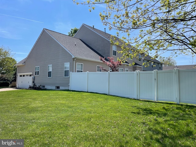 view of home's exterior featuring fence, a garage, a shingled roof, and a lawn