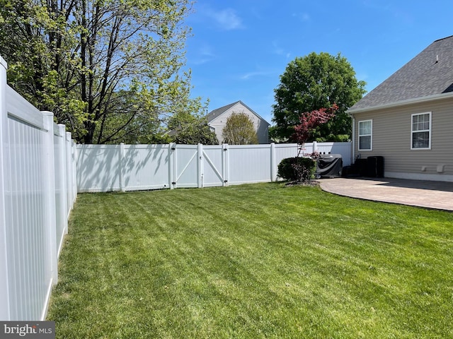 view of yard with a fenced backyard, a patio, and a gate