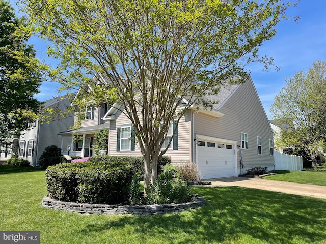 view of front facade with driveway, a front yard, fence, and an attached garage