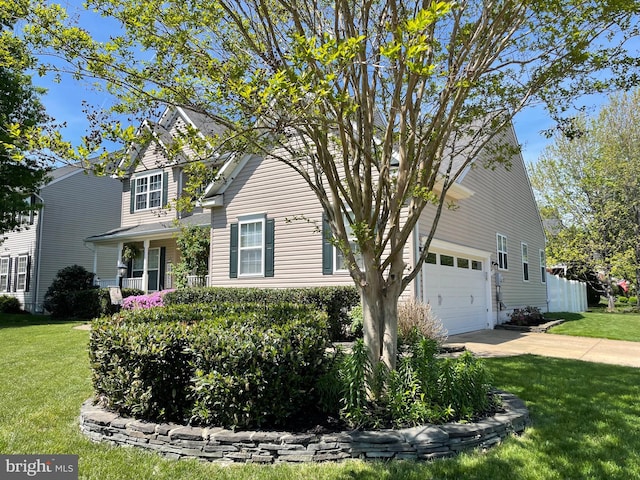 view of front of house with concrete driveway, a front yard, and a garage