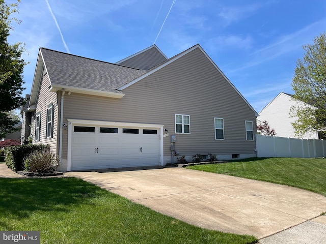 view of home's exterior with a shingled roof, a yard, driveway, and fence