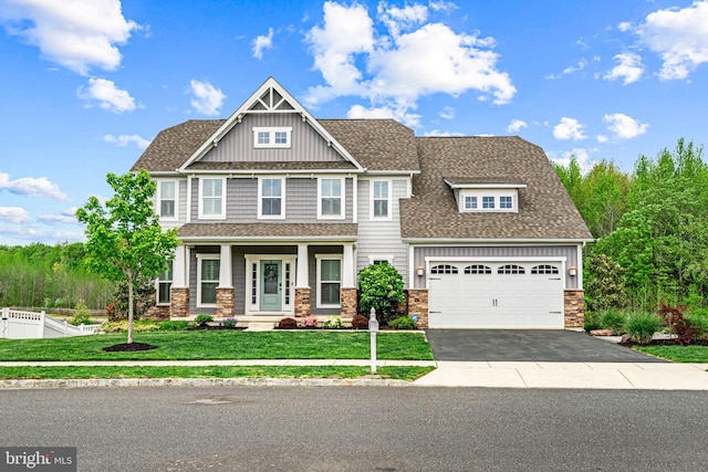 craftsman inspired home with board and batten siding, a front yard, fence, stone siding, and aphalt driveway