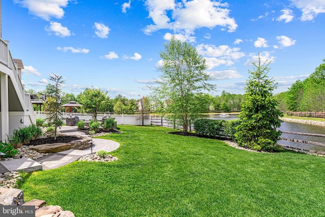 view of yard featuring a water view and fence