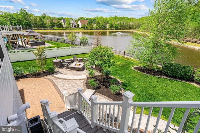 exterior space featuring a patio, a water view, a gazebo, a fire pit, and a fenced backyard