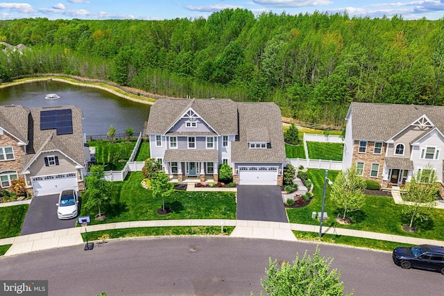 birds eye view of property with a water view and a view of trees