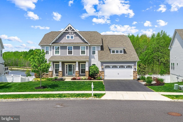 craftsman-style home with stone siding, fence, aphalt driveway, a front lawn, and a porch