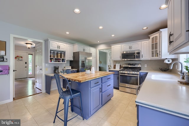 2969 Hearthside Ln, Lancaster, PA 17601 - kitchen featuring appliances with stainless steel finishes, a sink, blue cabinets, a center island, and healthy amount of natural light