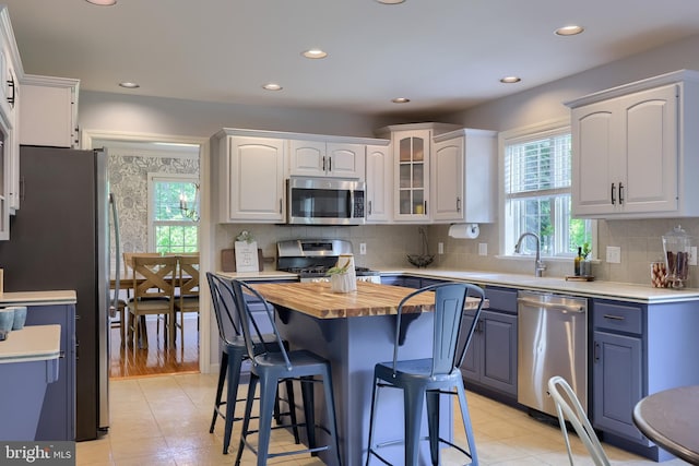 2969 Hearthside Ln, Lancaster, PA 17601 - kitchen featuring appliances with stainless steel finishes, wood counters, a kitchen bar, plenty of natural light, and recessed lighting
