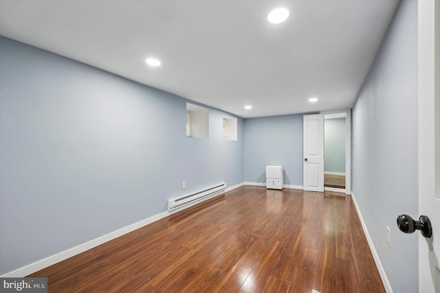 finished basement with recessed lighting, wood finished floors, baseboards, and a baseboard heating unit