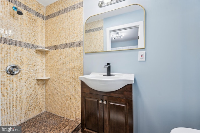 bathroom featuring a tile shower and vanity