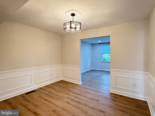 2649 Centennial Ct, Alexandria, VA 22311 - empty room with wood finished floors, a chandelier, wainscoting, and a decorative wall