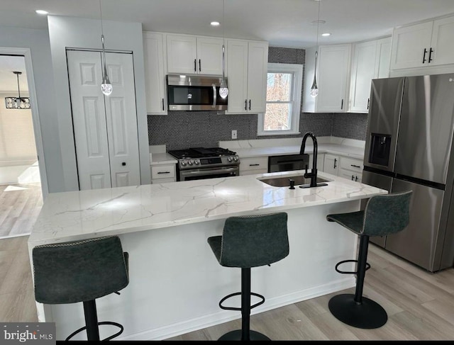 kitchen featuring a sink, tasteful backsplash, white cabinetry, and appliances with stainless steel finishes