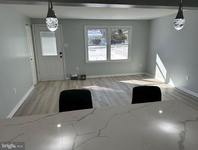 entryway with baseboards and wood finished floors