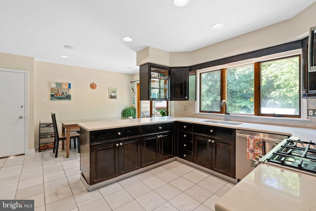 kitchen featuring a sink, light tile patterned floors, light countertops, backsplash, and recessed lighting