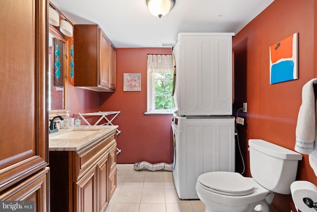 bathroom featuring stacked washer / dryer, toilet, tile patterned floors, and vanity