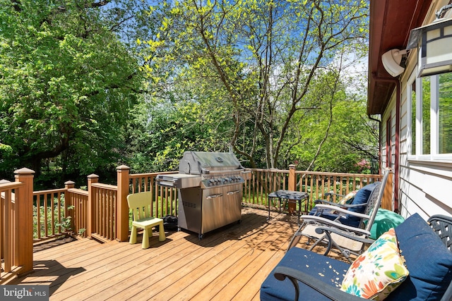 deck with area for grilling and view of scattered trees