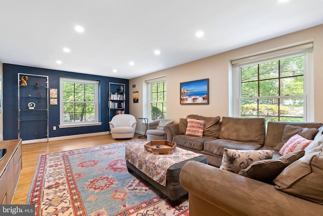 living area featuring plenty of natural light, recessed lighting, light wood finished floors, and baseboards