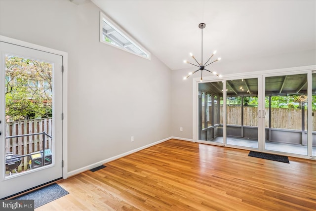 interior space with a chandelier, visible vents, plenty of natural light, and wood finished floors