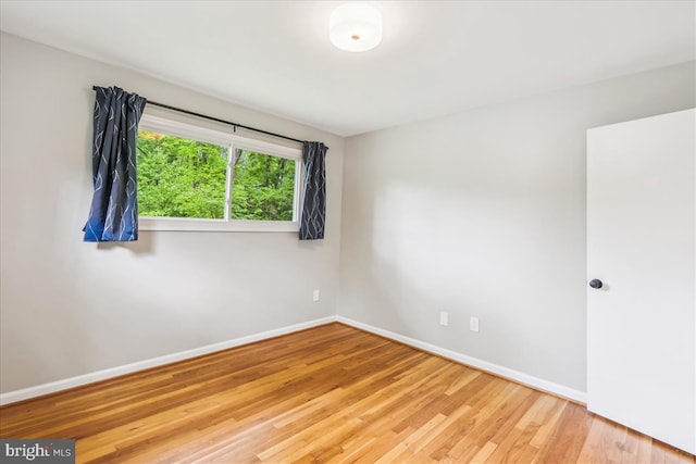 unfurnished room with wood finished floors and baseboards