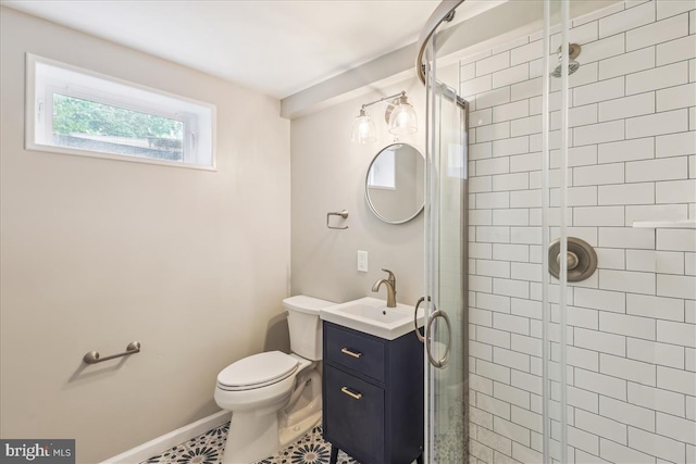 bathroom with a stall shower, baseboards, vanity, and toilet