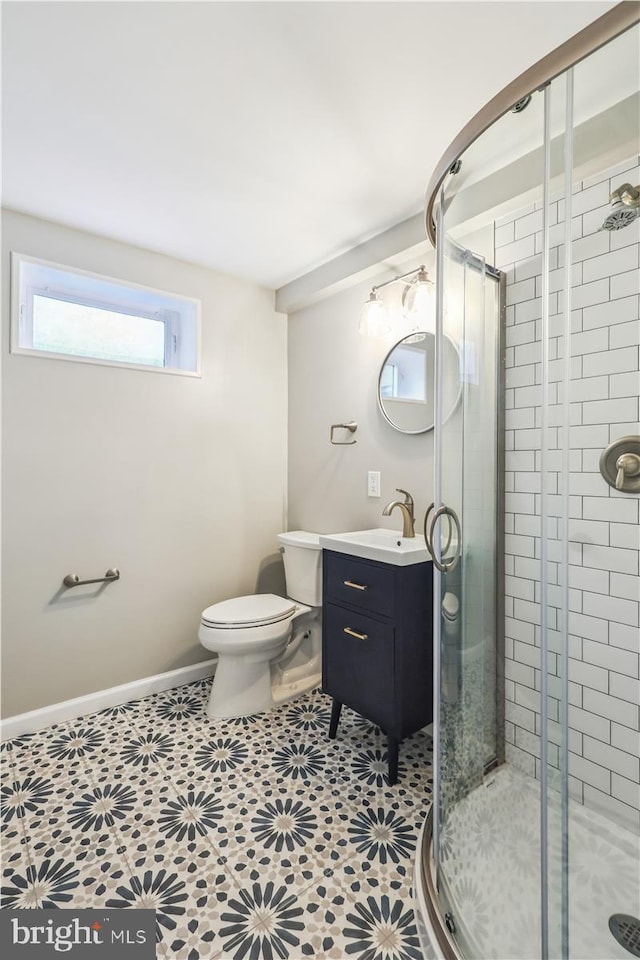 full bath featuring toilet, baseboards, vanity, and a shower stall