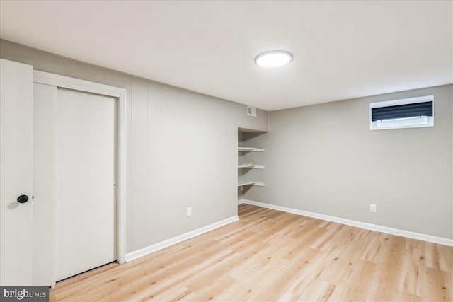 below grade area featuring baseboards, visible vents, and wood finished floors