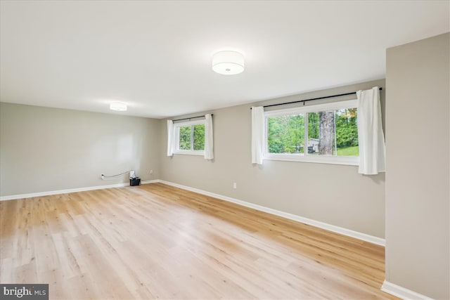 spare room featuring baseboards and wood finished floors