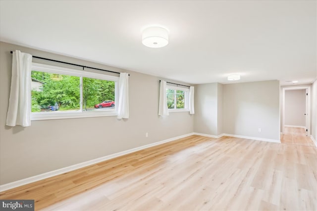 empty room featuring light wood-type flooring and baseboards
