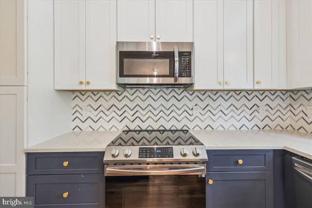 kitchen with light countertops, decorative backsplash, and stainless steel appliances