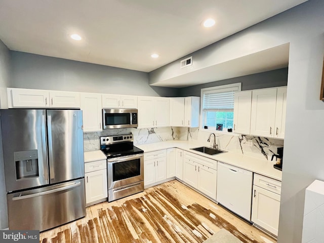 1241 Ridge Rd, Feasterville Trevose, PA 19053 - kitchen with a sink, light wood-type flooring, visible vents, white cabinets, and appliances with stainless steel finishes