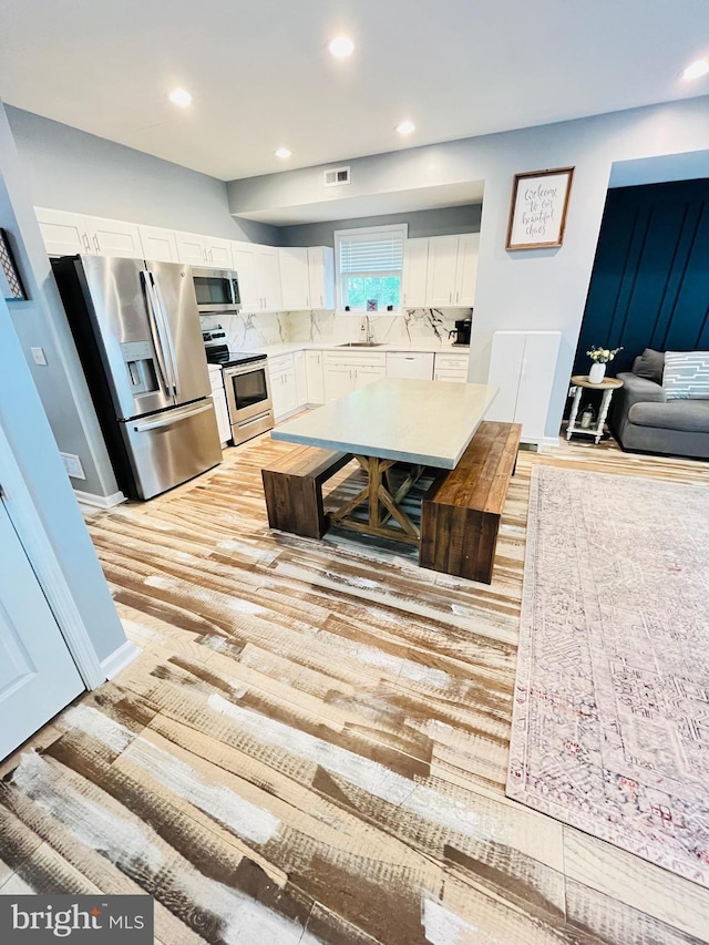 1241 Ridge Rd, Feasterville Trevose, PA 19053 - kitchen featuring a sink, white cabinetry, decorative backsplash, light countertops, and appliances with stainless steel finishes