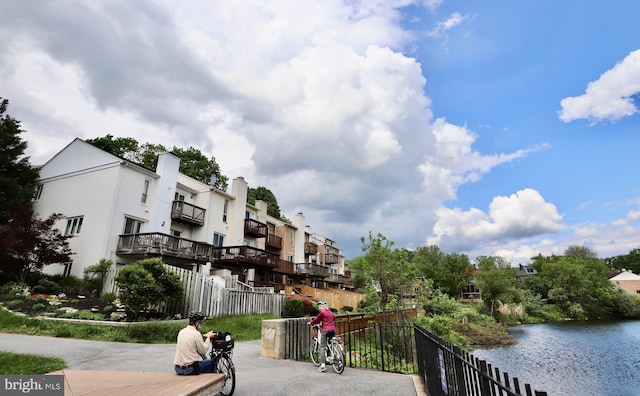 surrounding community with fence and a water view